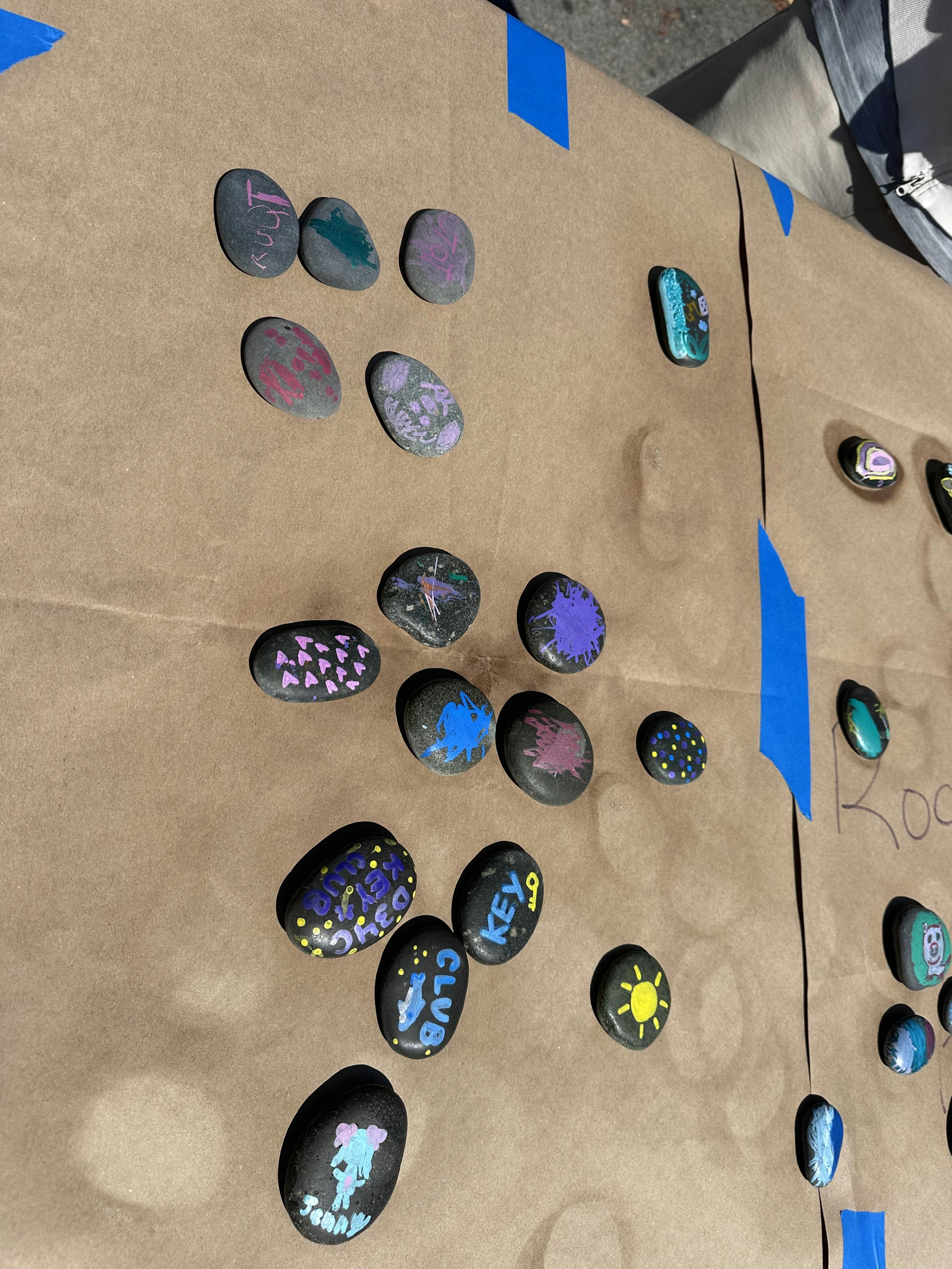 Decorative painted stones with various designs on brown paper