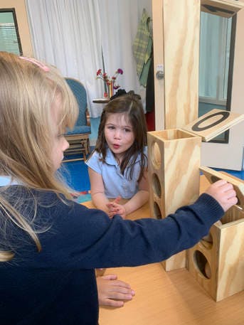 Two children playing with wooden blocks