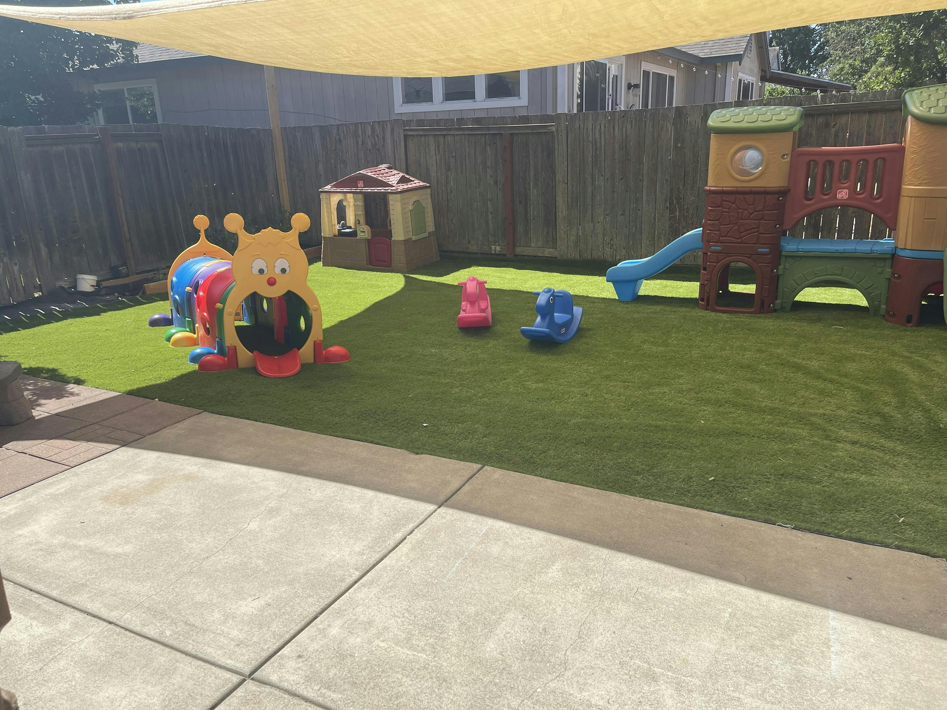 Outdoor play area with artificial turf and colorful play structures