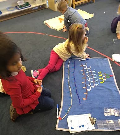 Children on floor with learning materials