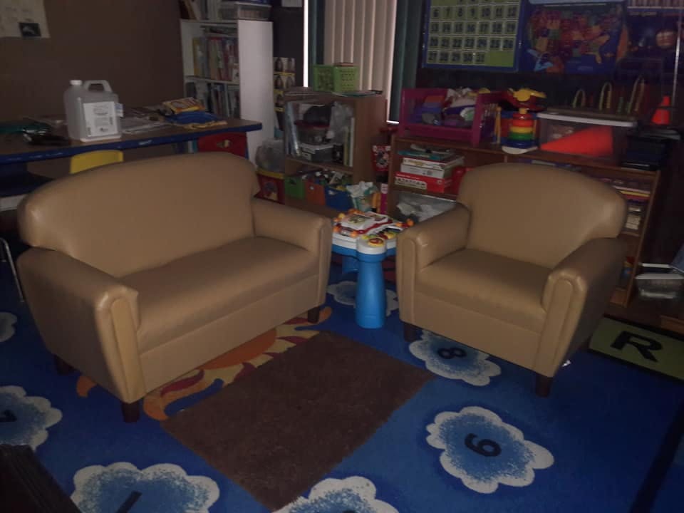 Two small couches in a room with a blue rug