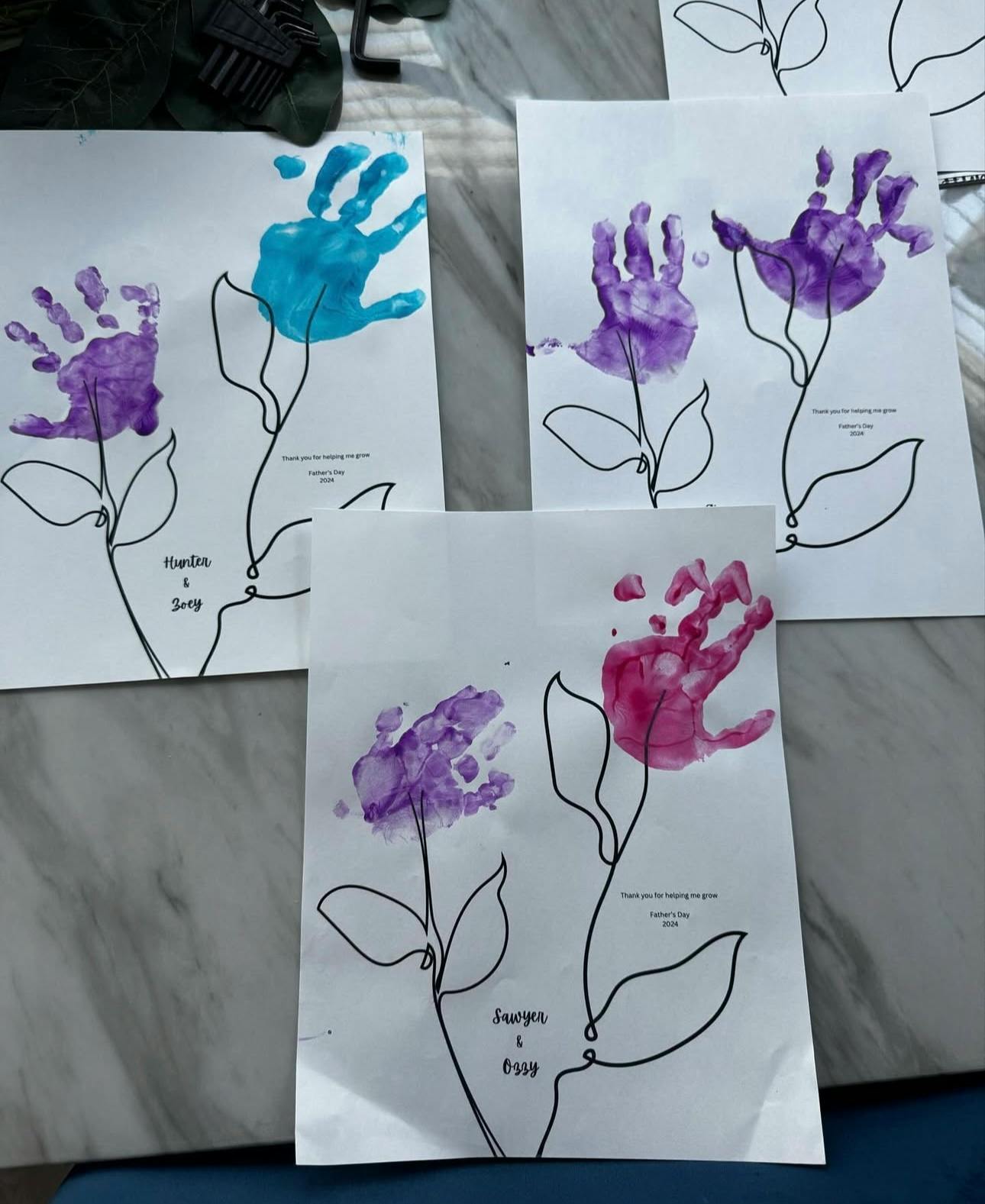 Multiple pieces of paper with handprint flowers