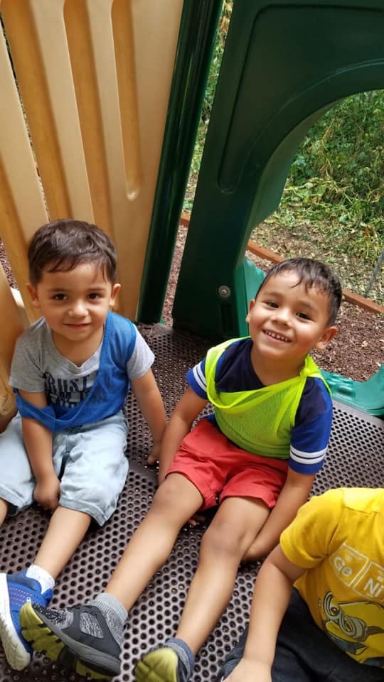 Two children sitting on playground equipment