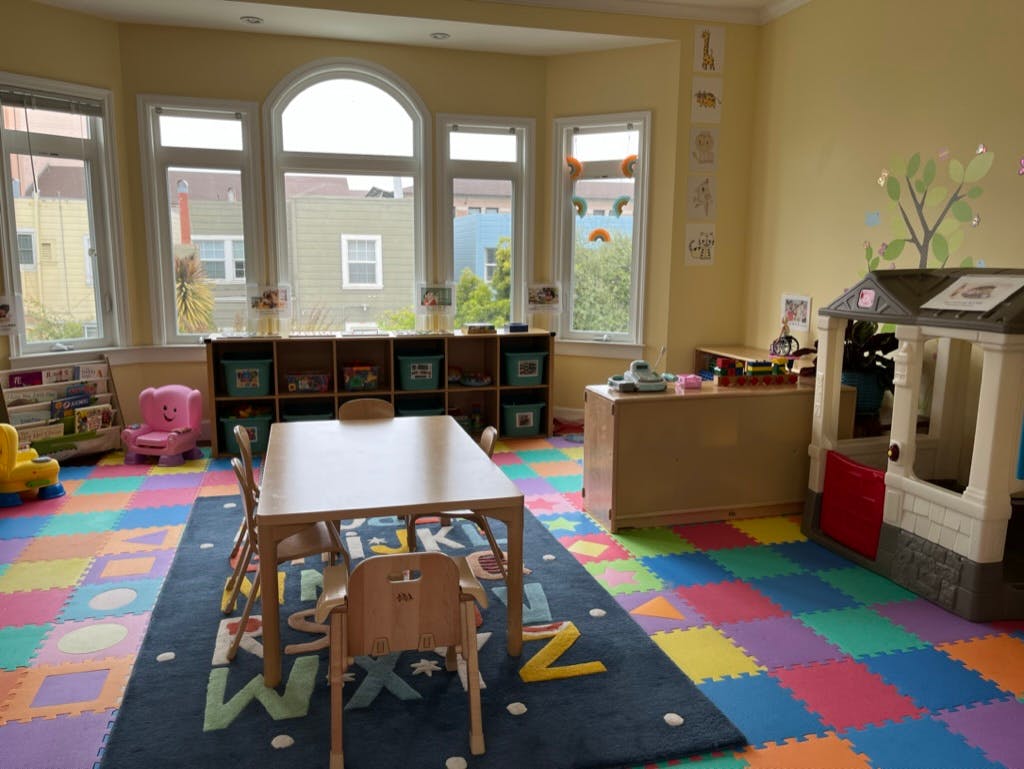 Playroom with colorful floor mats, a table and chairs, and toys