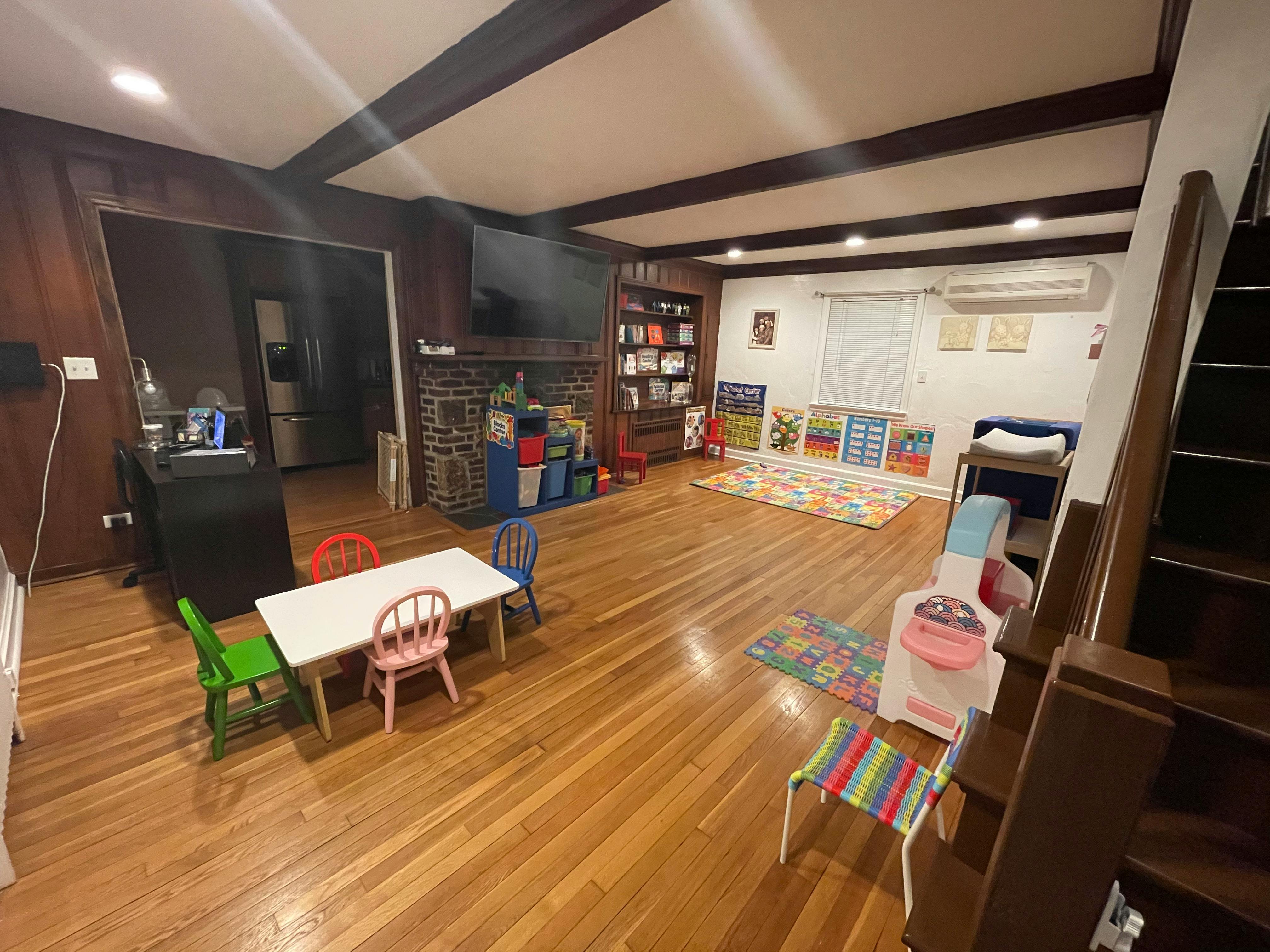 Playroom with small table and chairs, toys, and a bookshelf