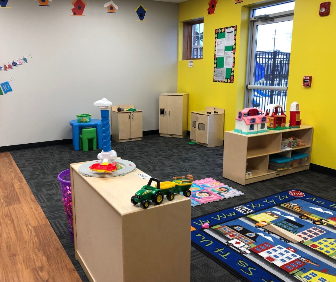 Playroom with toys, small tables, and a city-themed rug