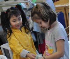 Two children looking at something held in their hands