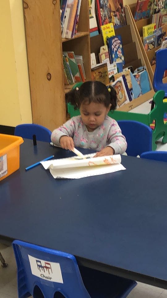 Child sitting at a table and painting