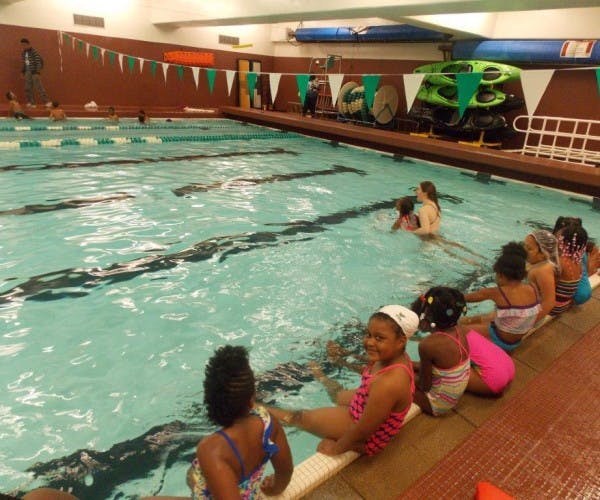 Children sitting on the edge of a swimming pool