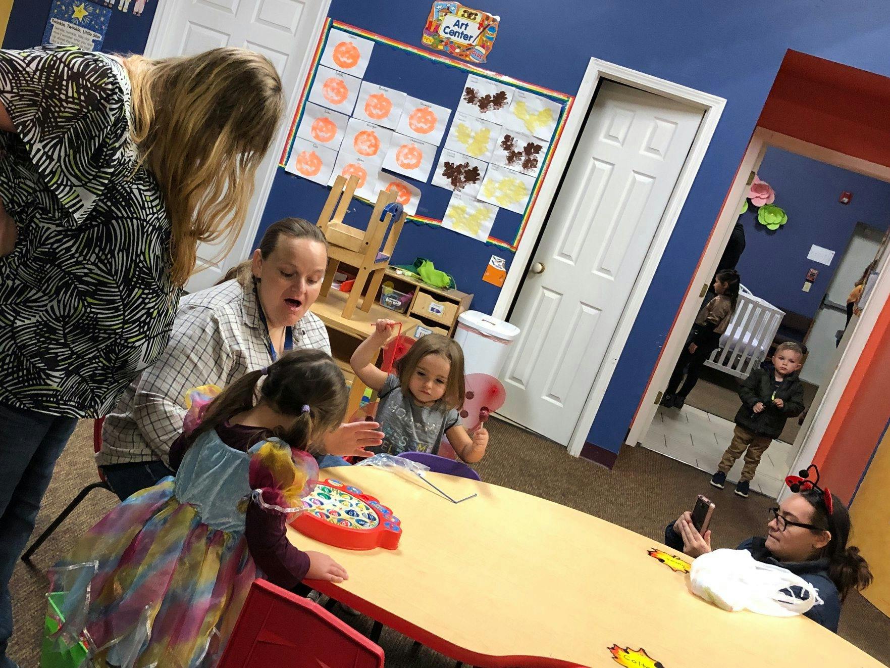 Adults and children gathered around a table in a classroom