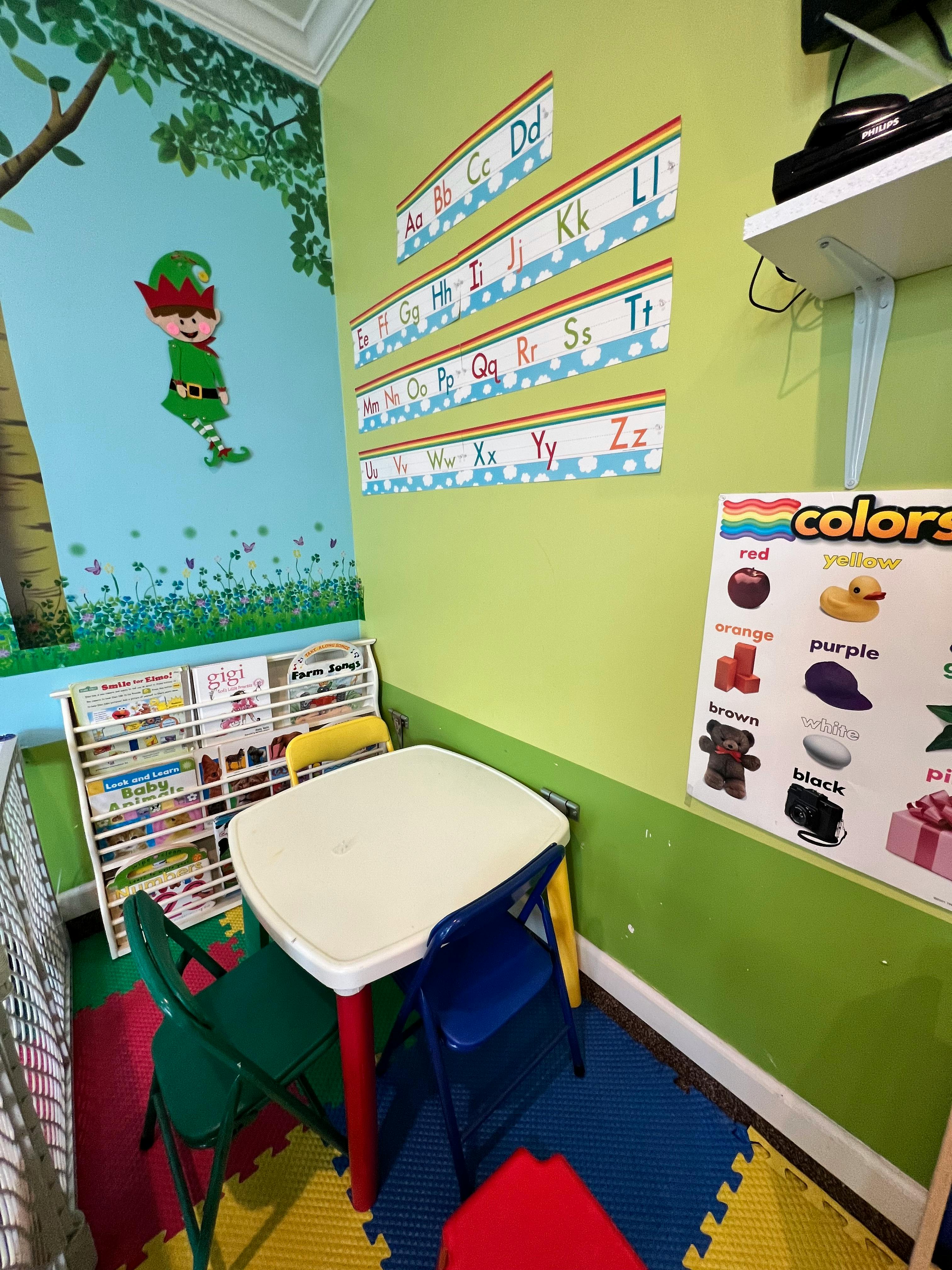 Children's classroom with alphabet and colors charts, small table and chairs
