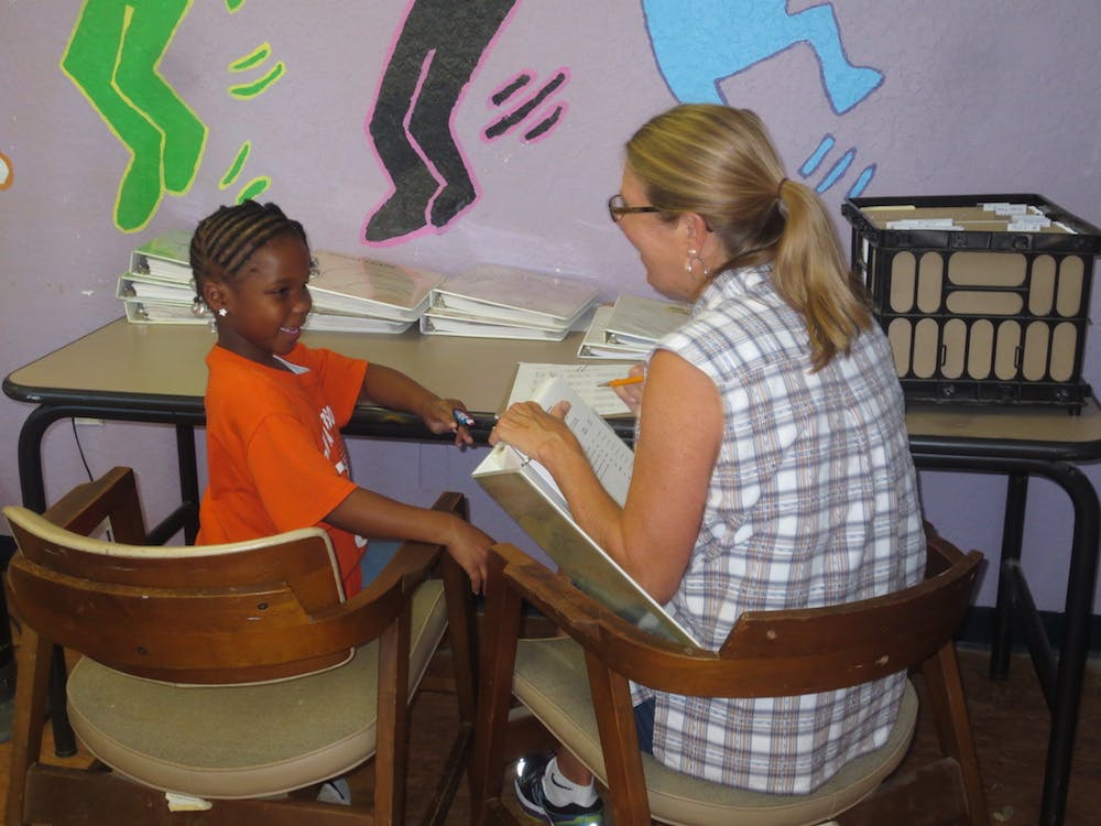 Adult and child sitting at a table with papers