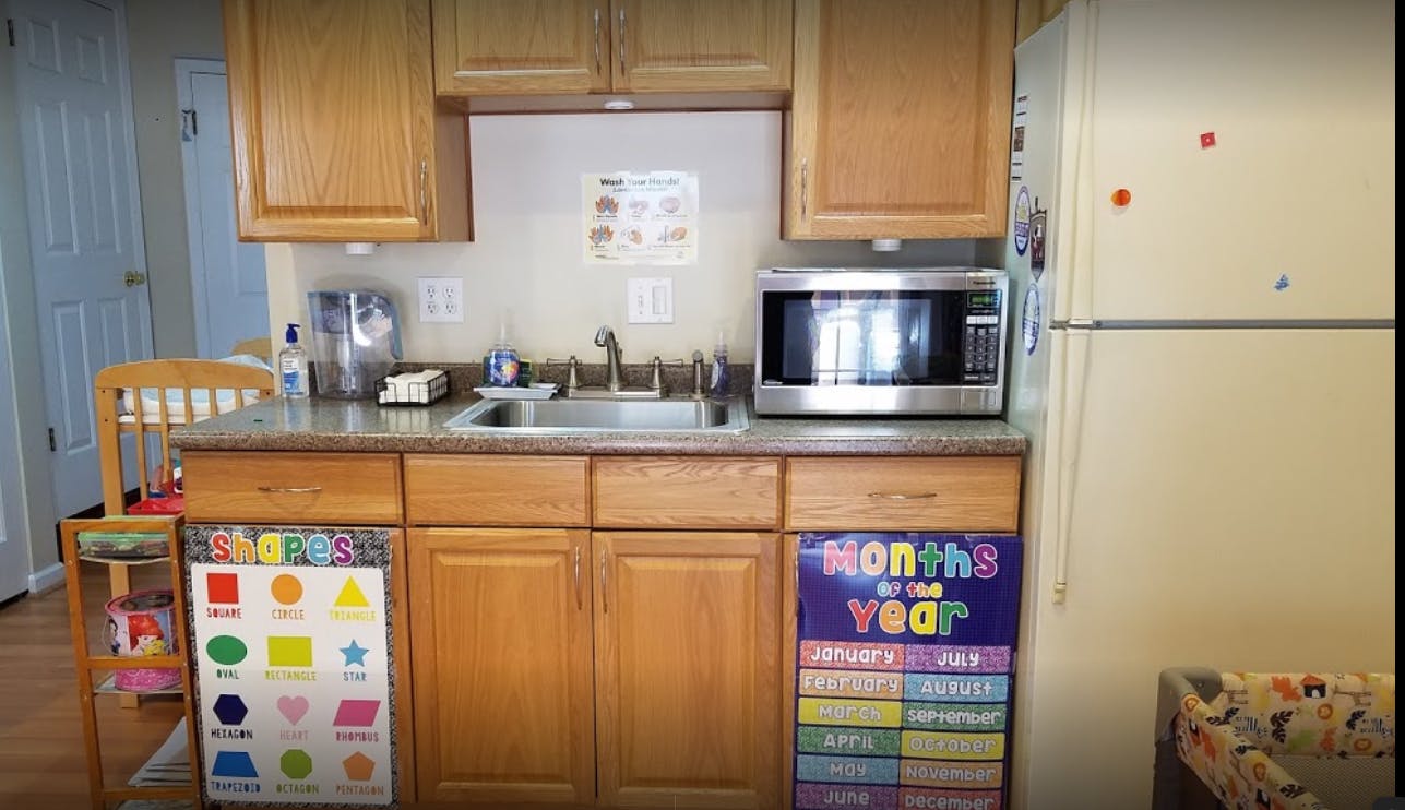 Kitchen counter with sink, microwave, and educational posters