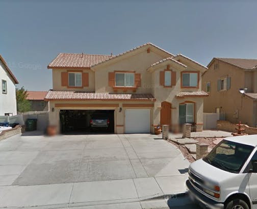 Two-story house with an open garage and a white van in the foreground