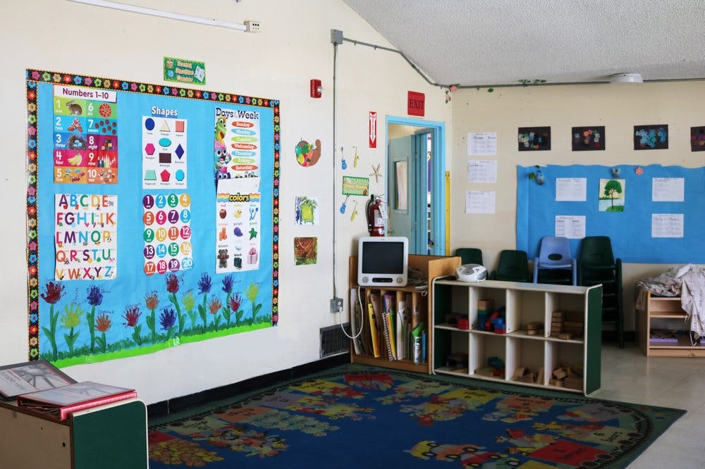 Classroom with bulletin boards, small chairs, and storage shelves