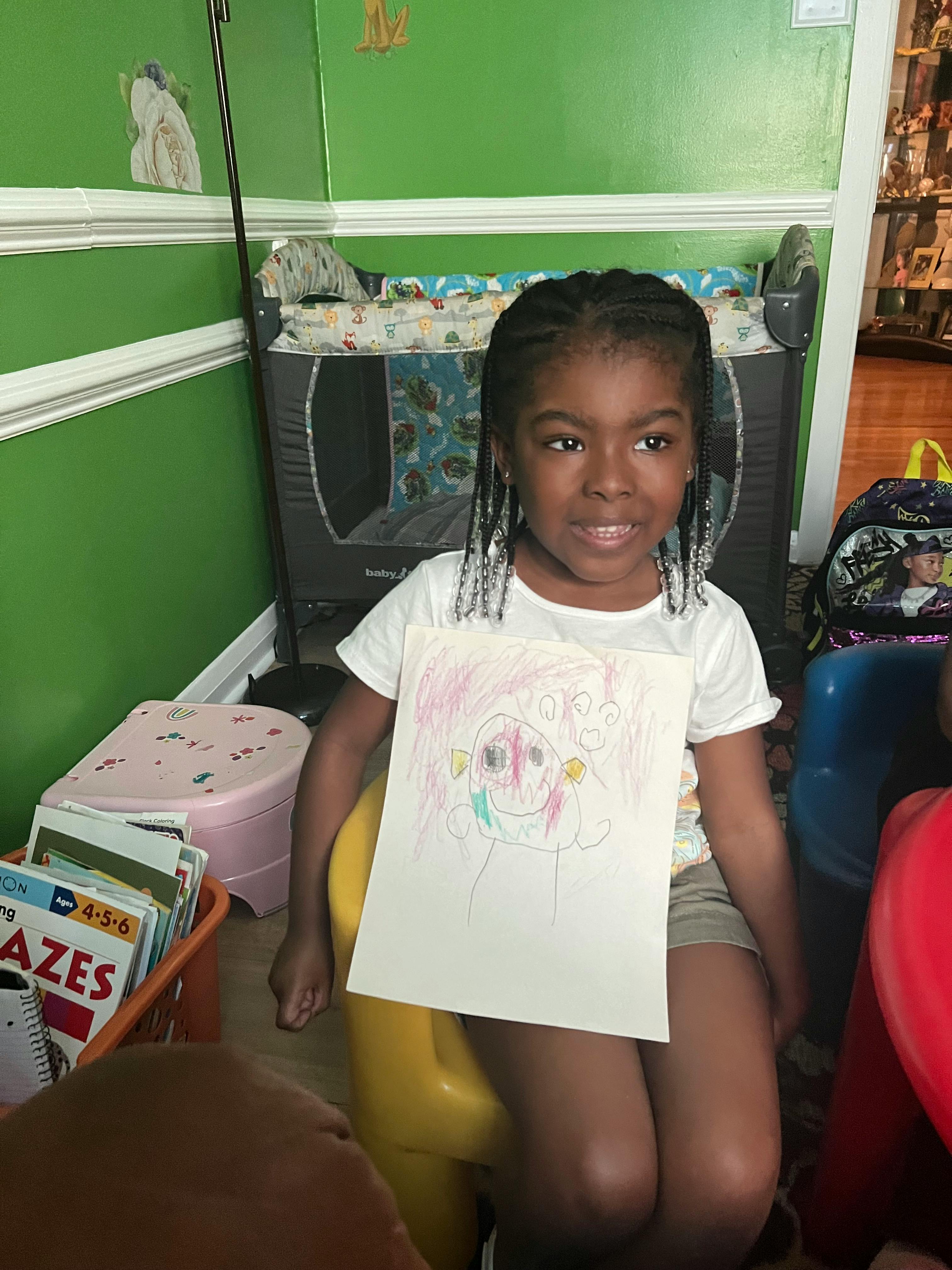 Child holding up a drawing
