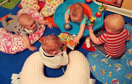 Multiple babies playing with toys on the floor