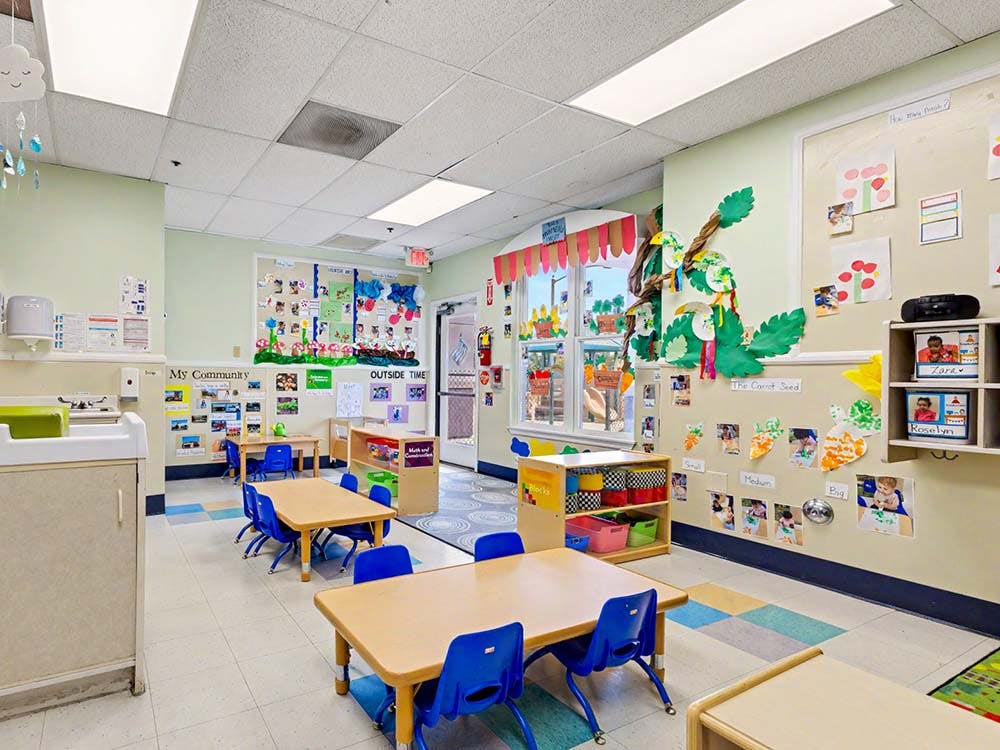 Classroom with tables, chairs, and child artwork on walls