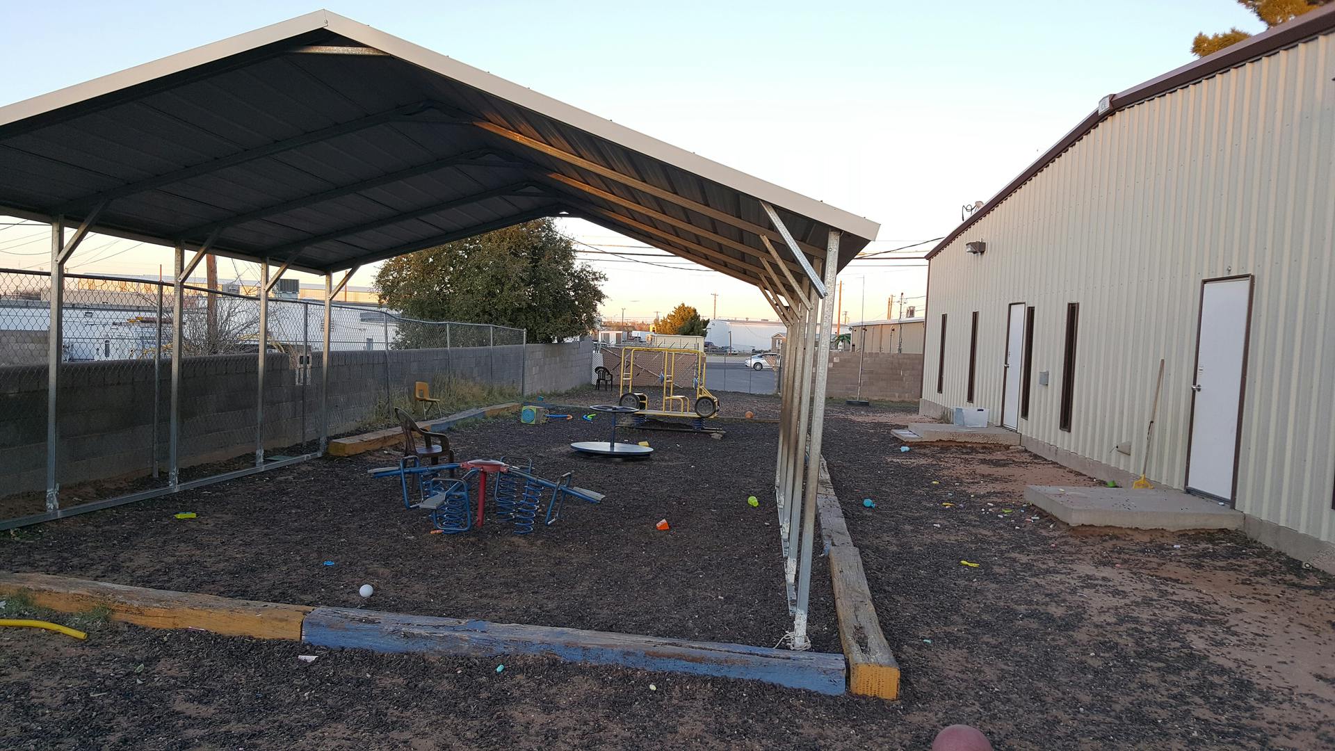 Outdoor play area with a shade structure and a building