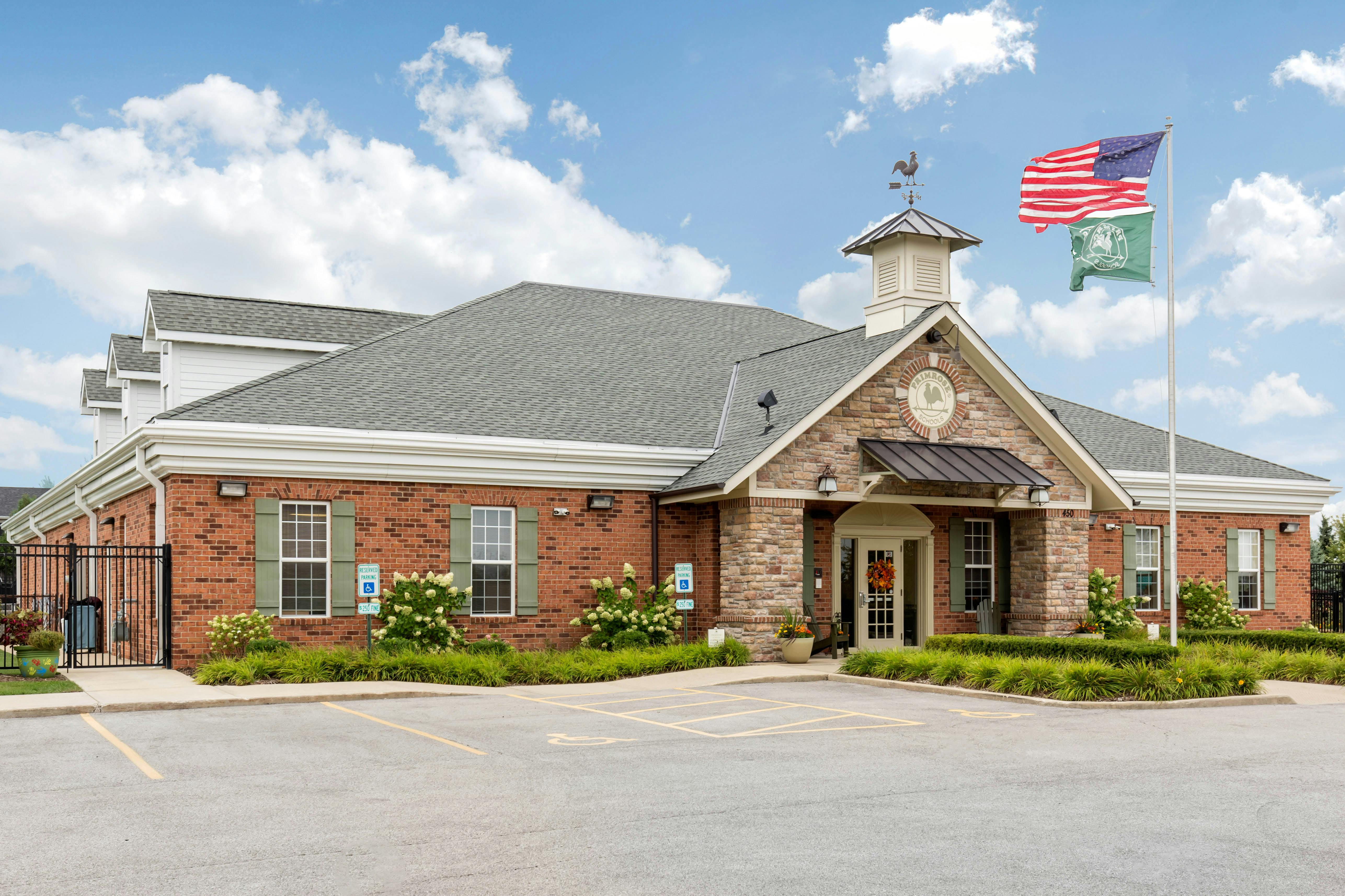 Brick building with a stone entrance, cupola, and flags flying