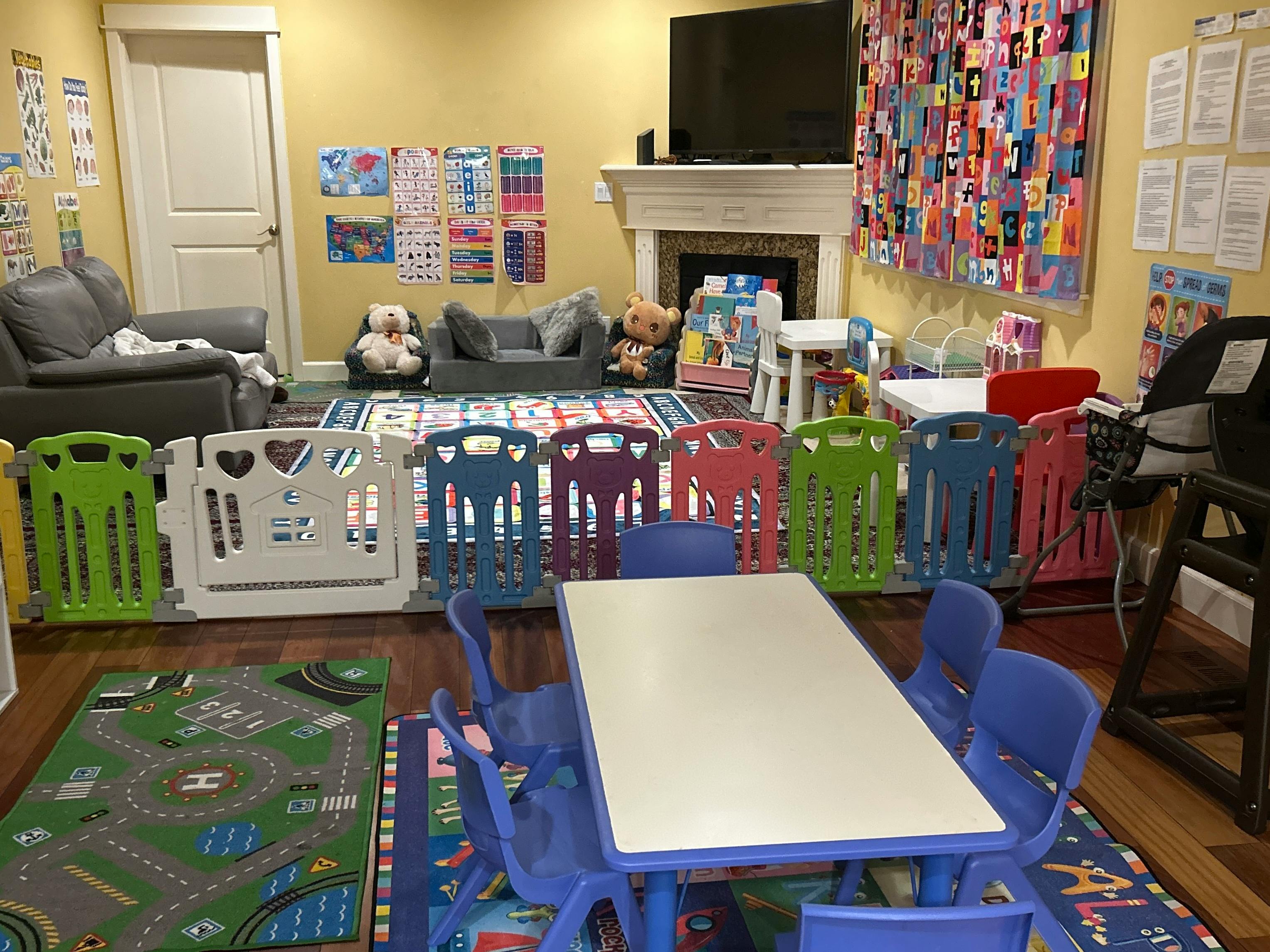 Playroom with colorful playpen, small table and chairs, and toy rug