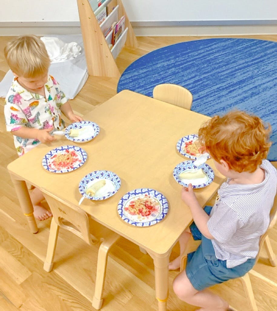 Two children at a table with plates of food