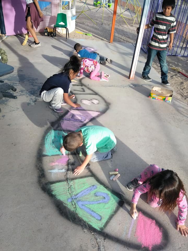 Children drawing with chalk on pavement