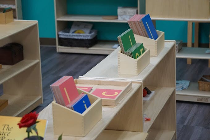 Montessori classroom with wooden shelves and learning materials