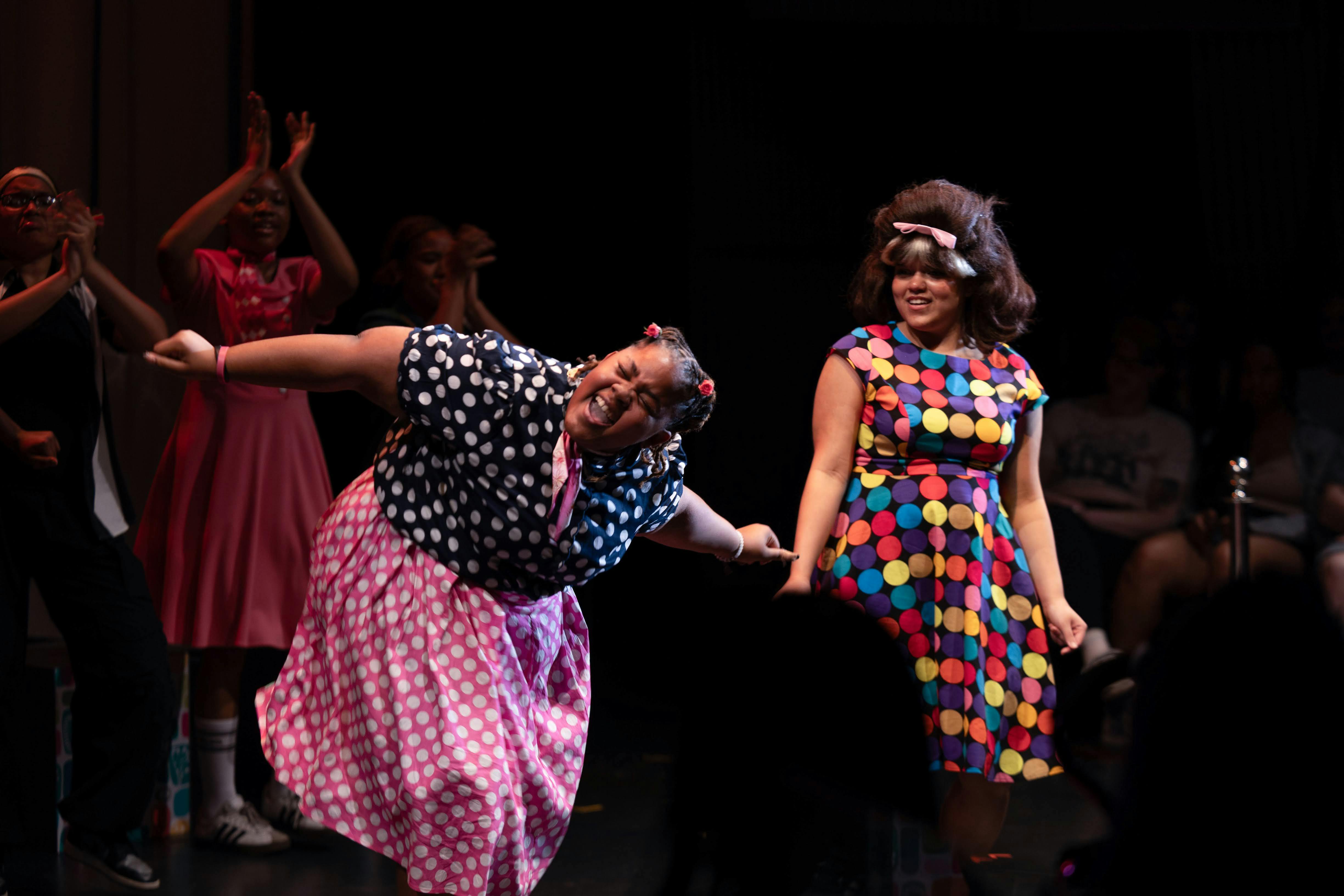 People dancing on a stage in vintage-style polka dot clothing