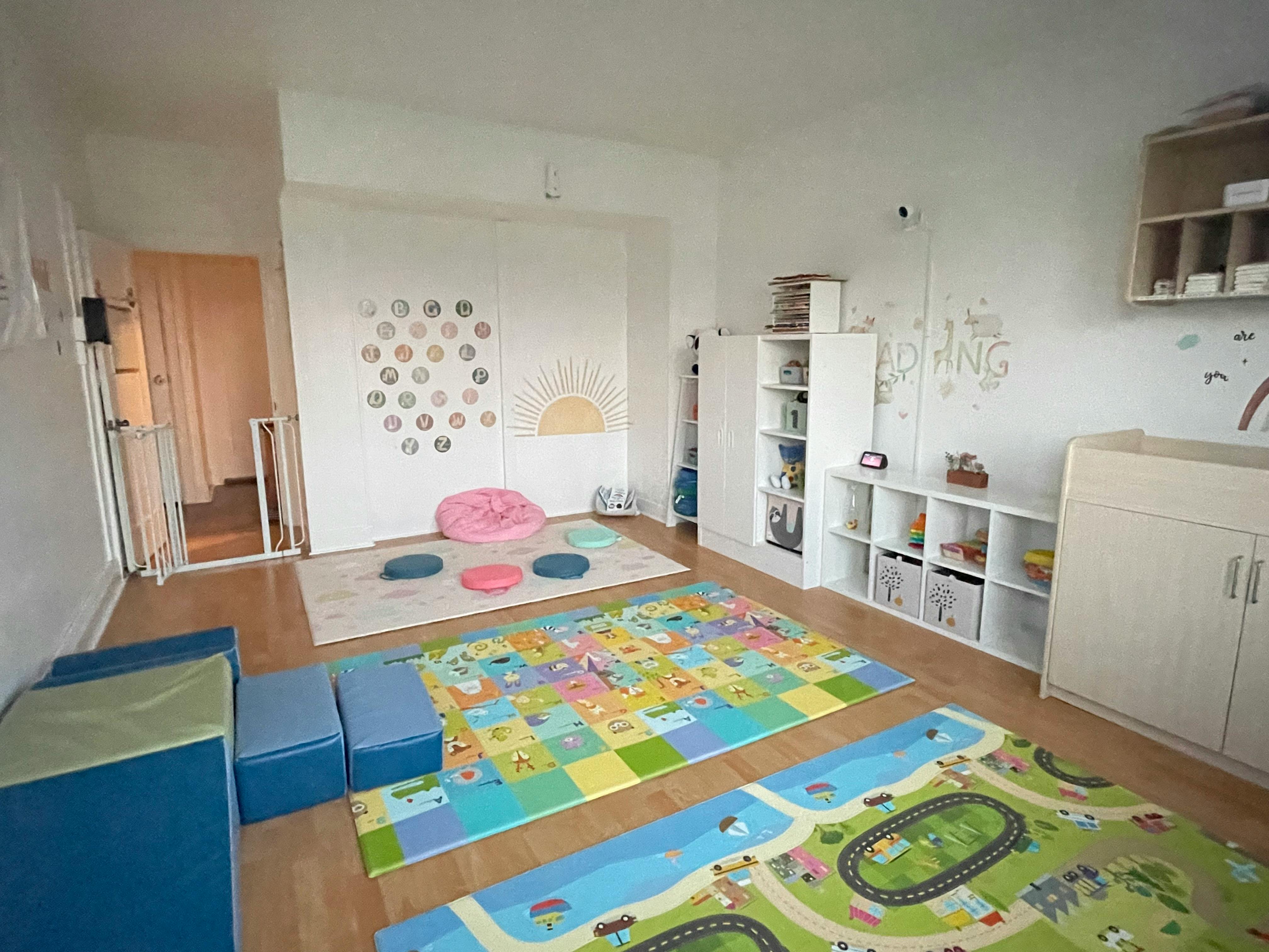 Playroom with colorful rugs, beanbags, and storage shelves