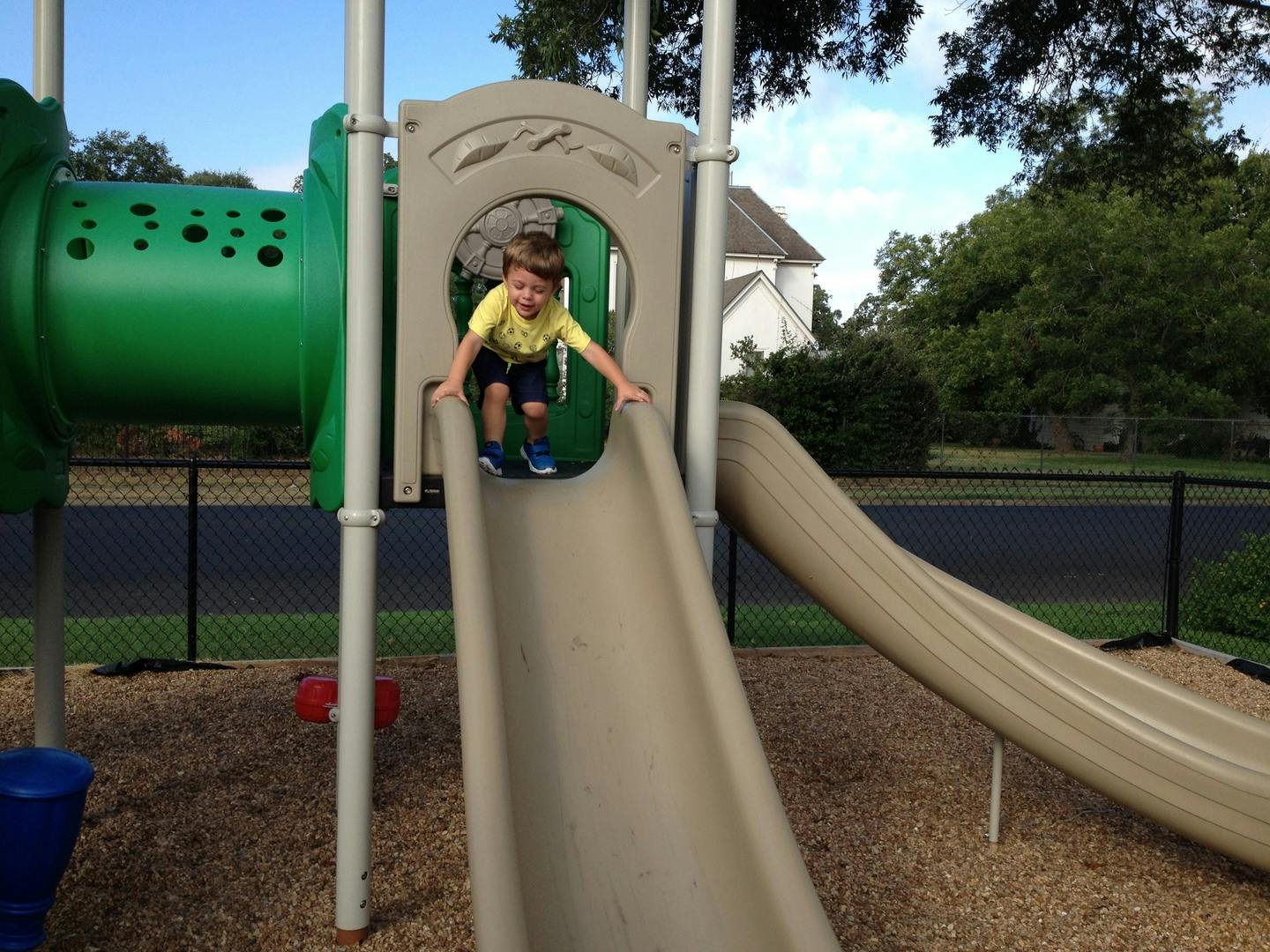 Child at the top of a playground slide