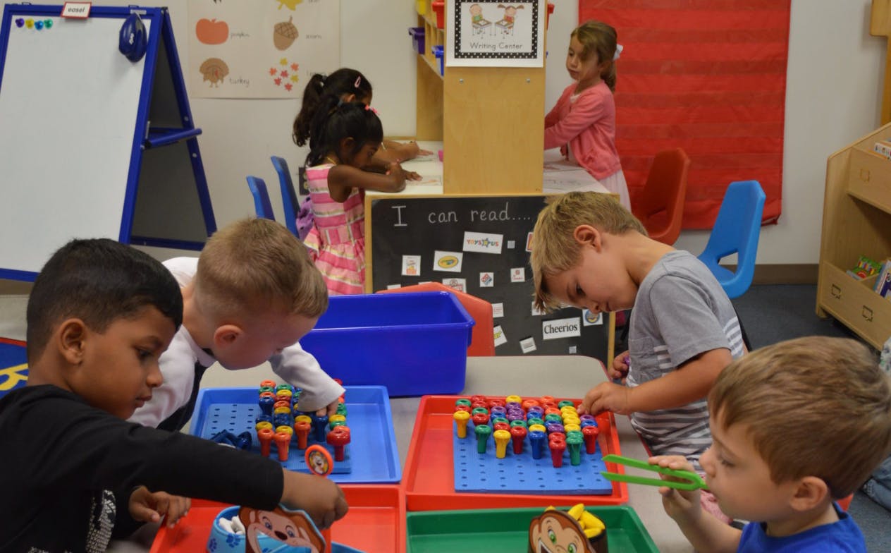 Children playing with colorful building blocks in a classroom
