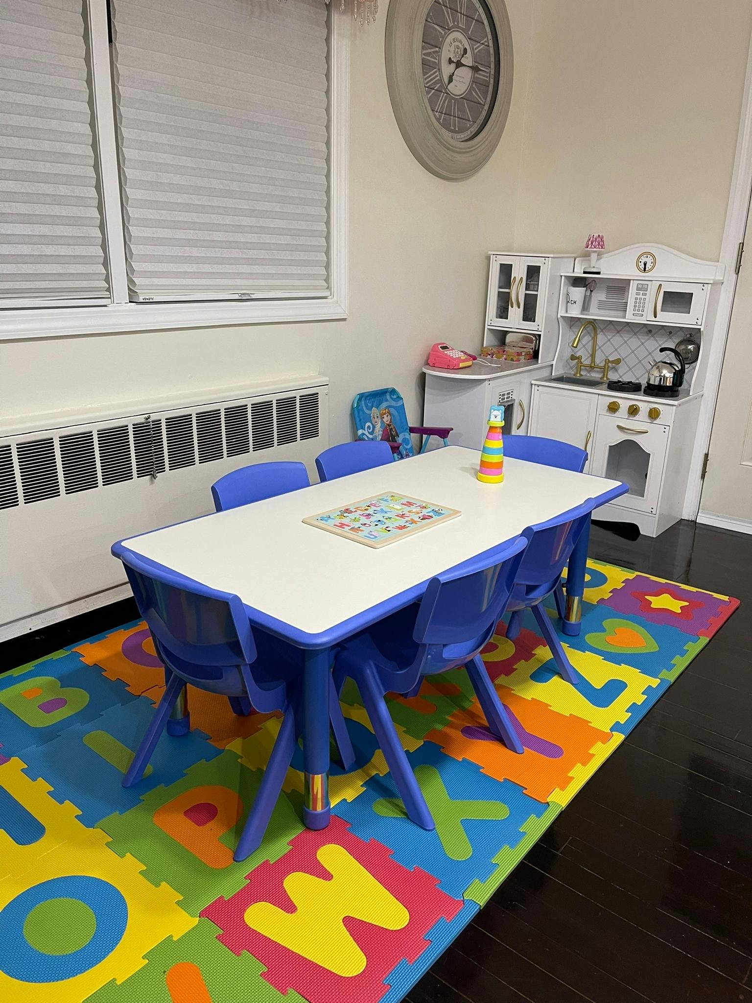 Children's play area with a table and chairs on an alphabet mat