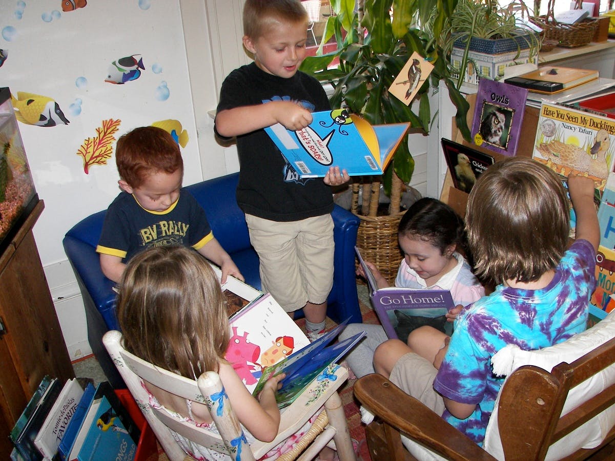 Group of children reading books in a classroom