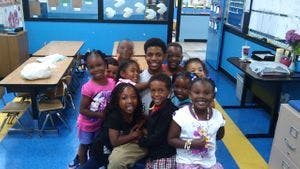 Group of children and one teen in a classroom