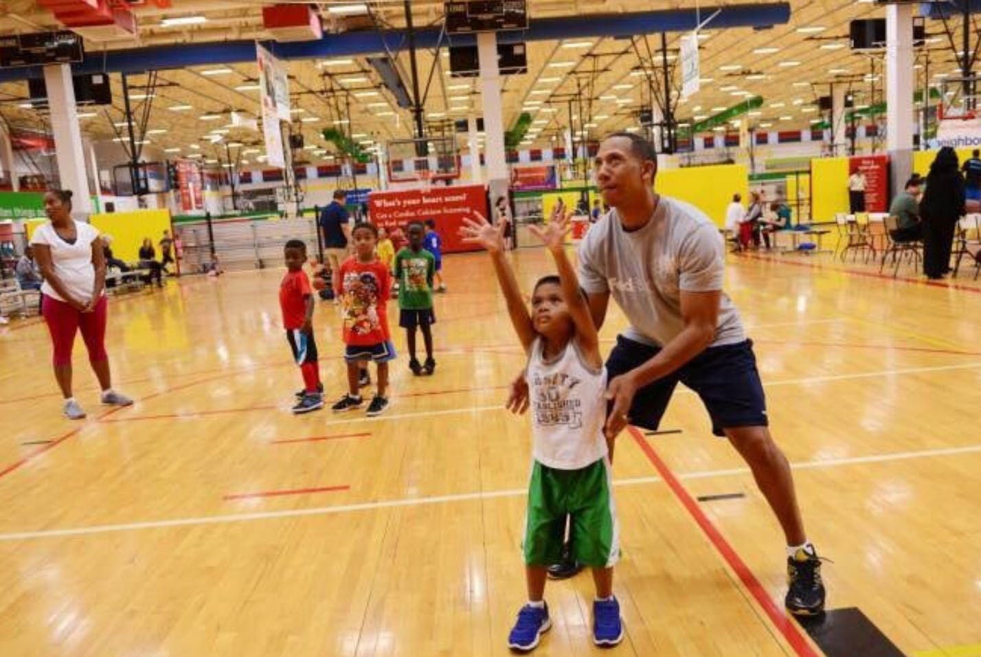 Adult and child on a basketball court, child with arms raised