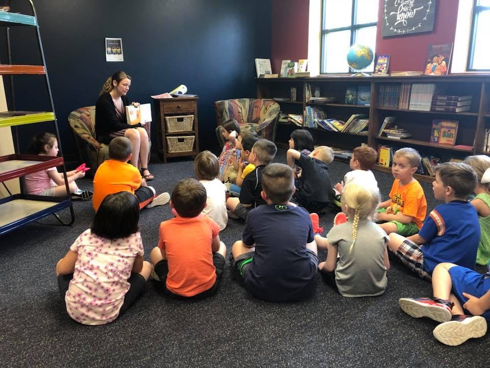 Adult reading to a group of children sitting on the floor