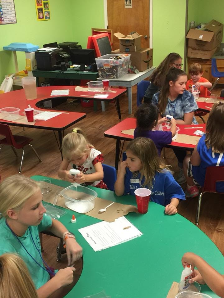 Children and teens at tables in a classroom