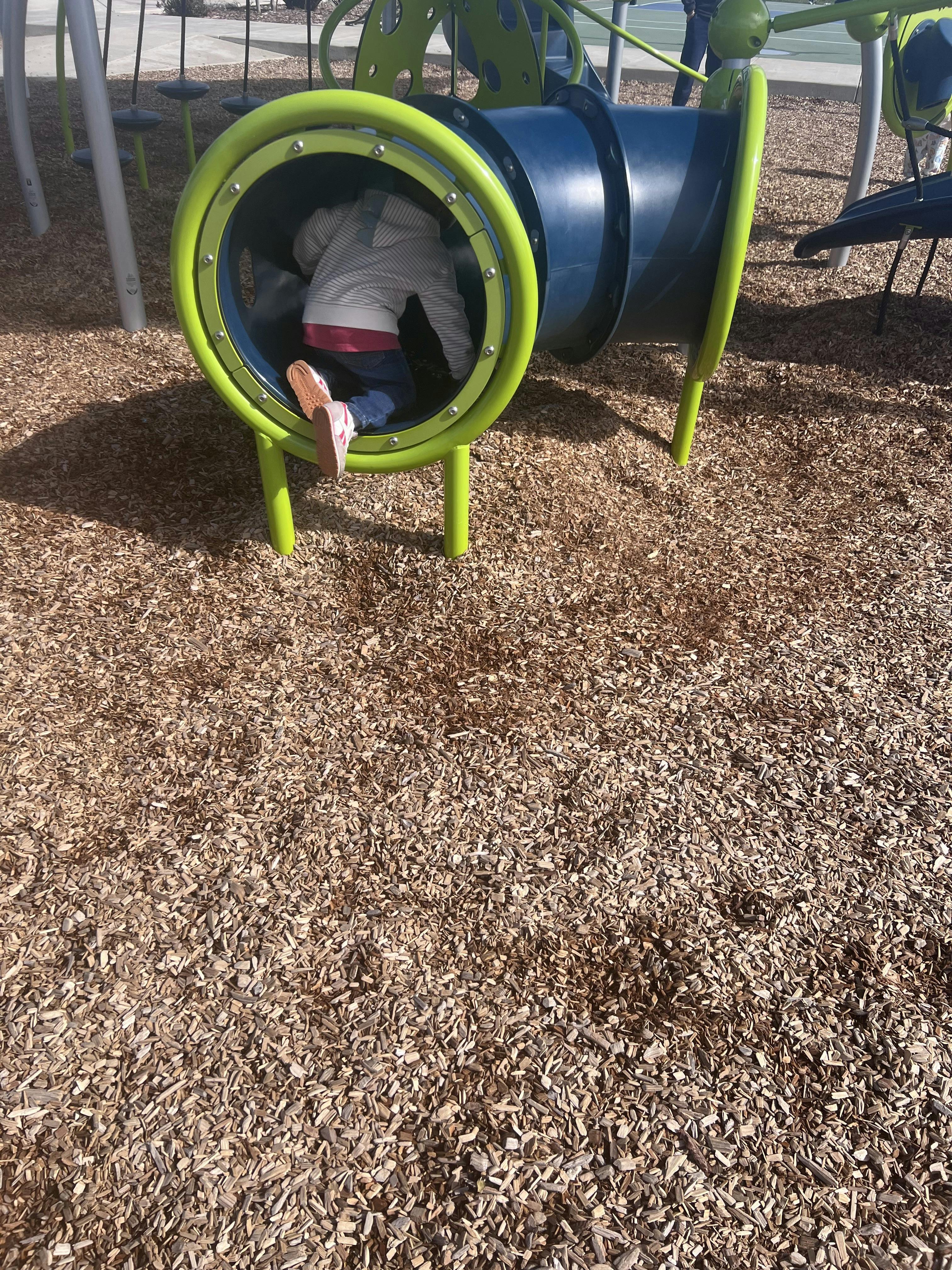 Child crawling through a tunnel on a playground