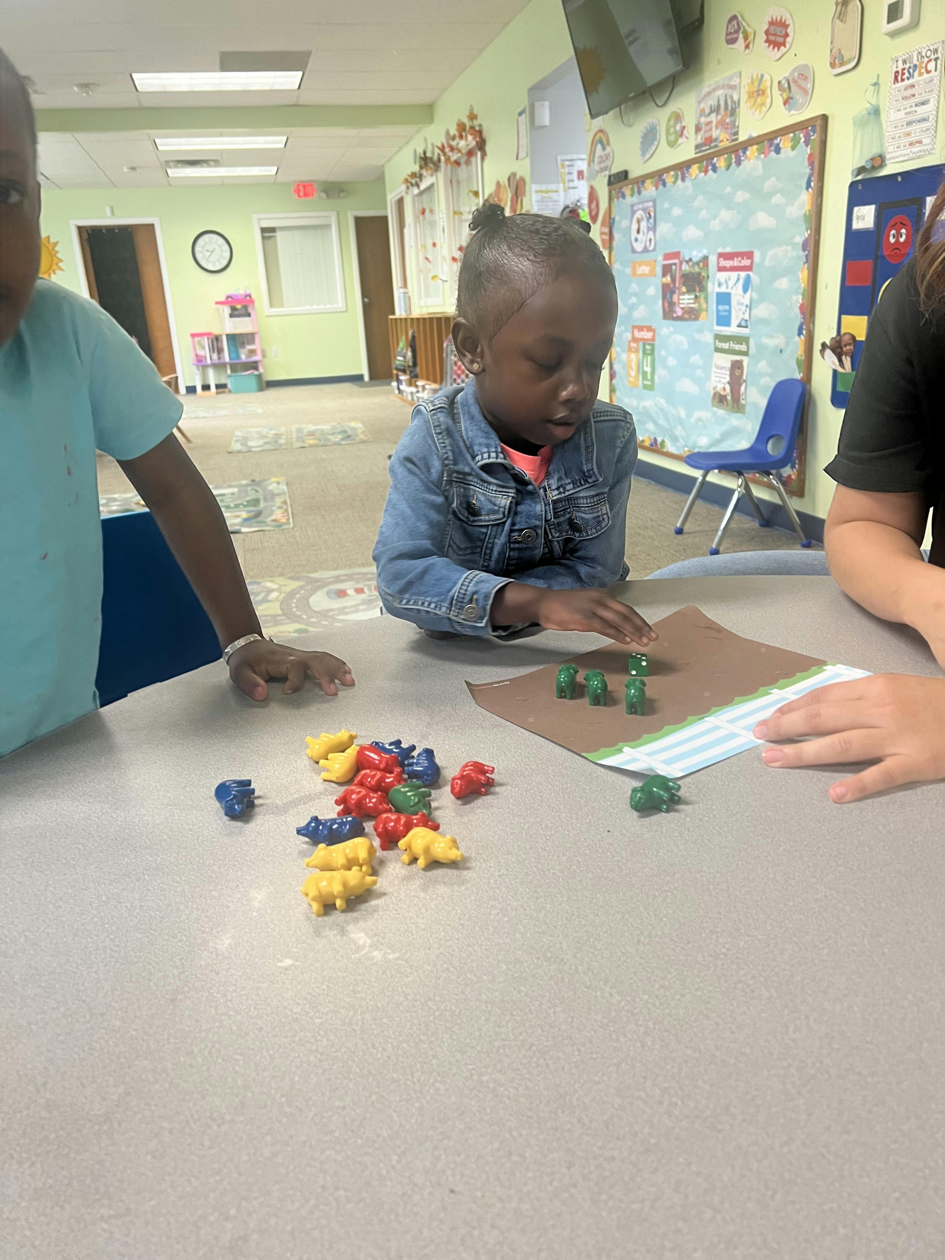 Child playing with colorful animal counters on a table