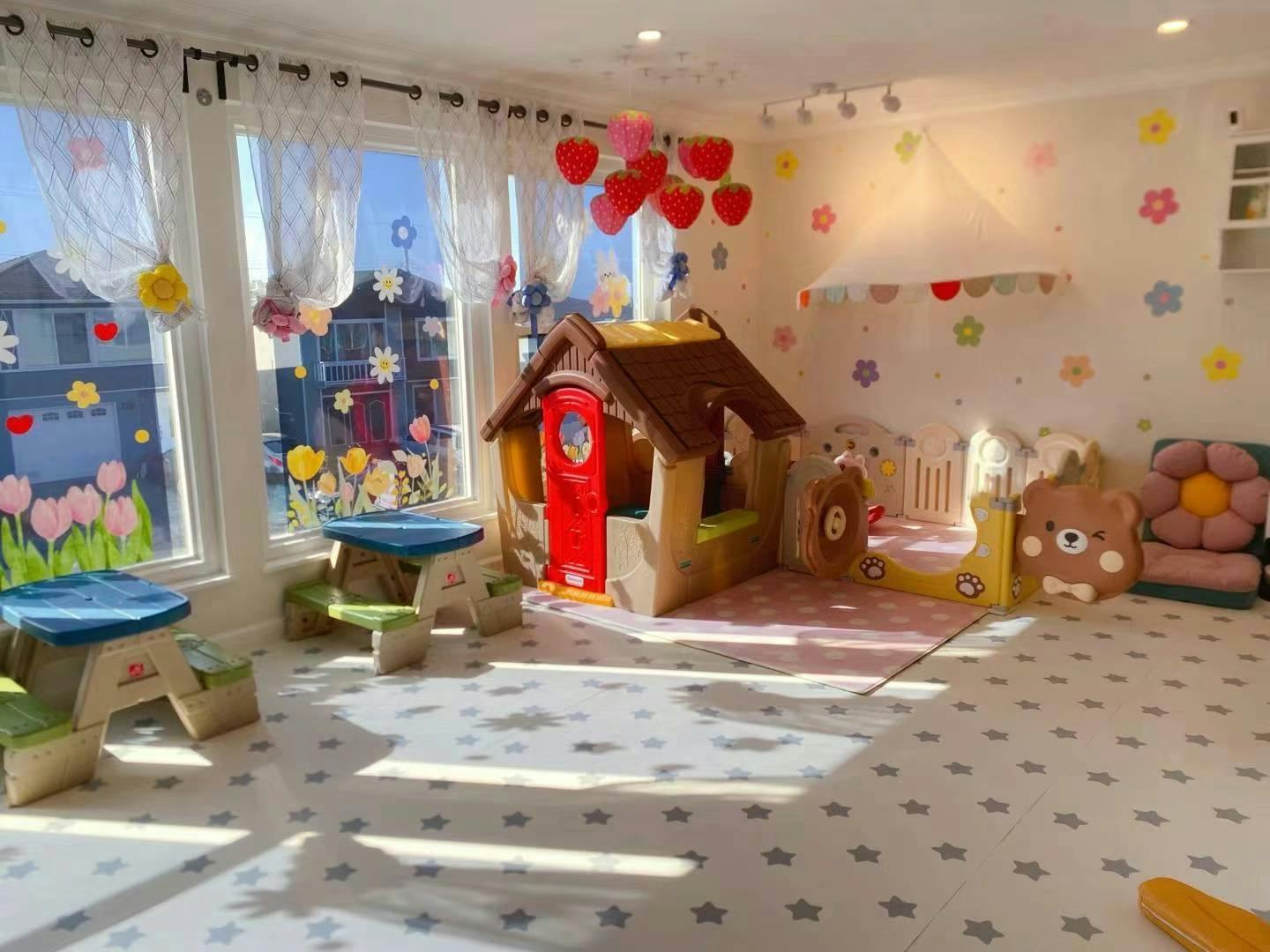 Playroom with a playhouse, small tables, and flower wall decals
