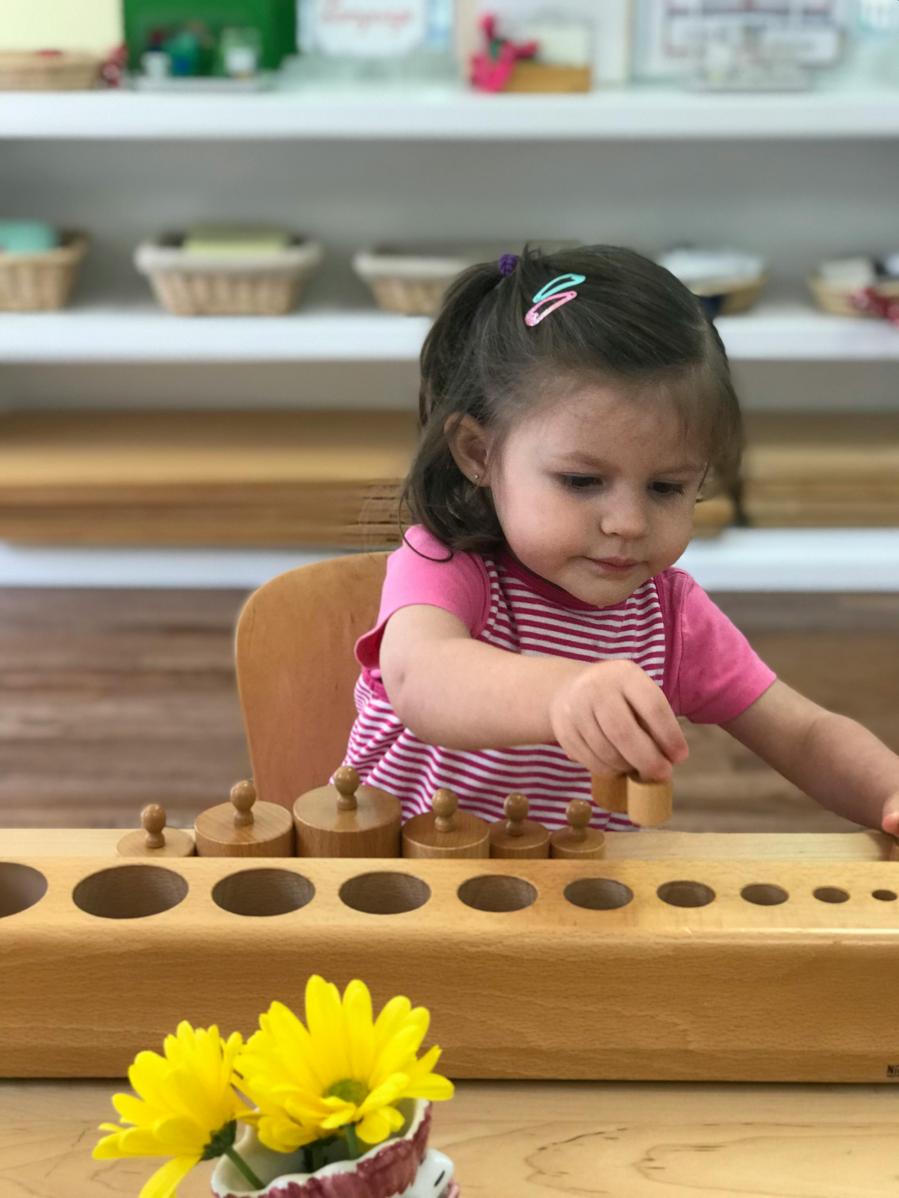Child playing with wooden cylinder blocks