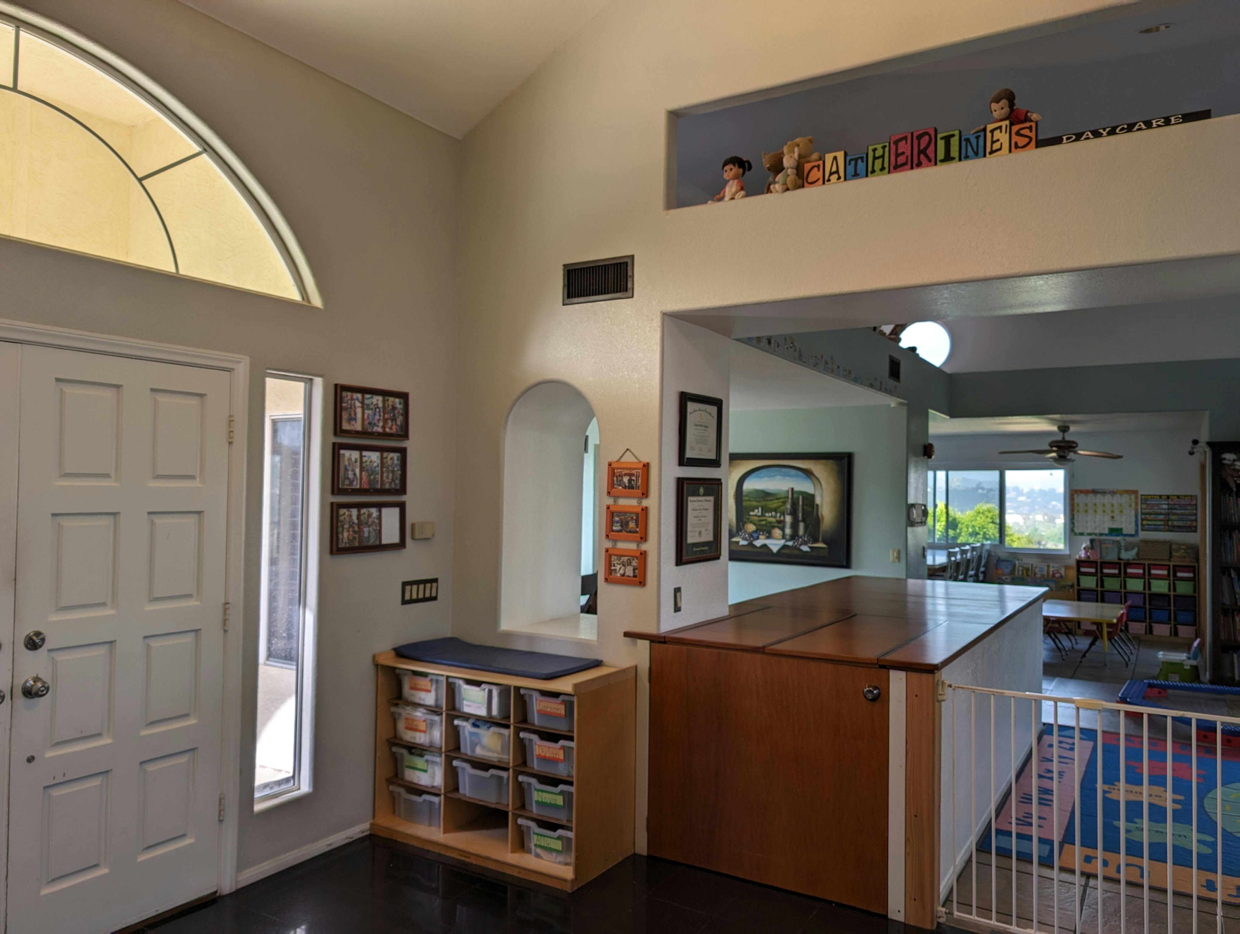Entryway with a white door, storage unit, and view into another room