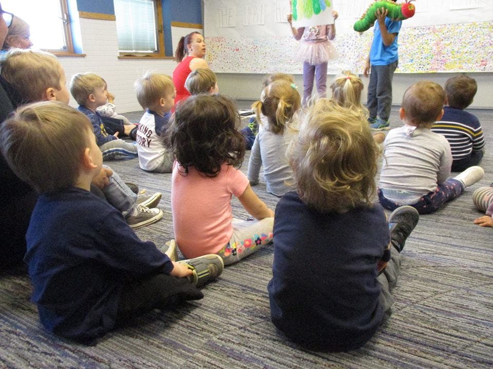 Children sitting on the floor watching a presentation