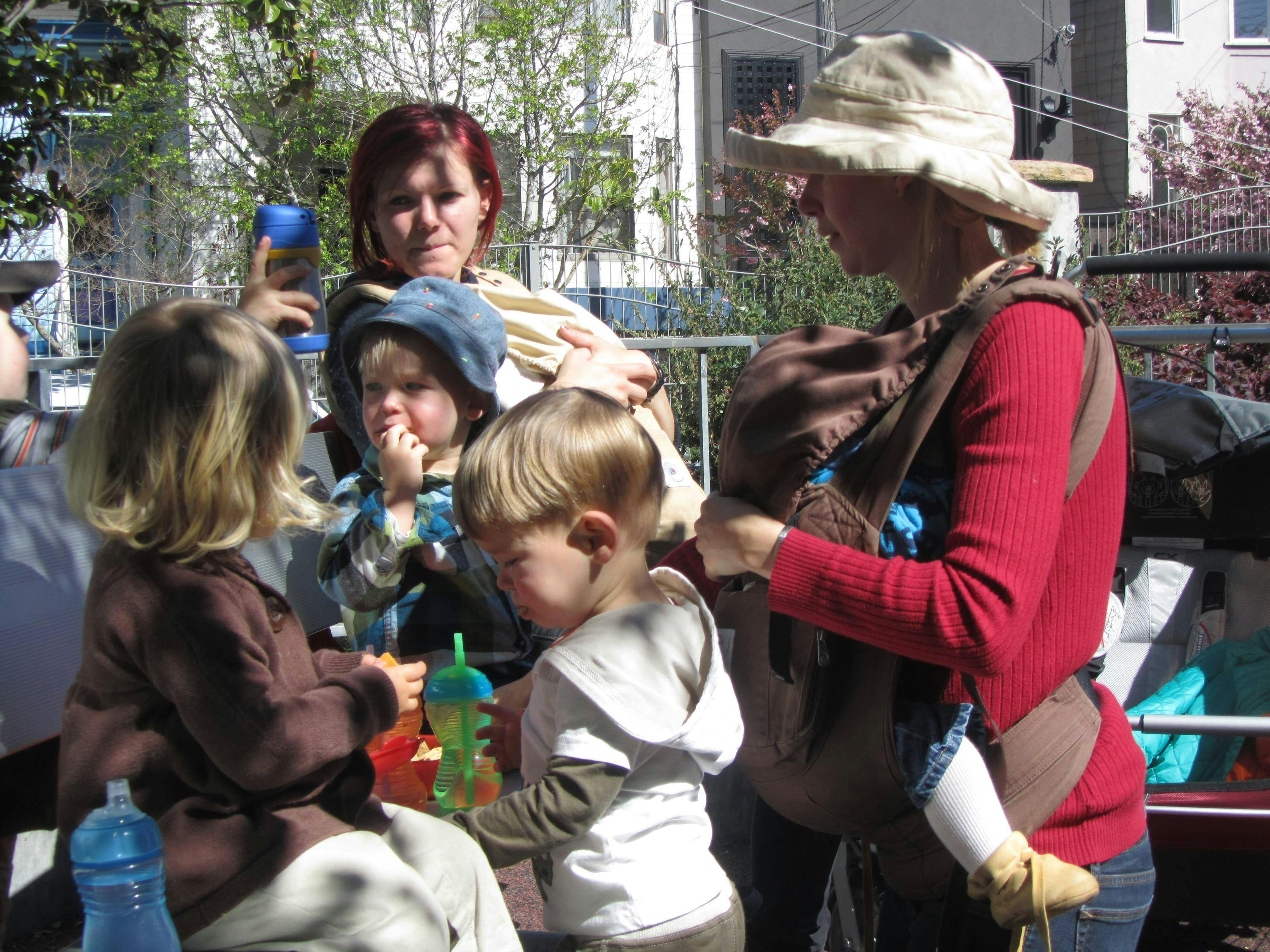 Two people with multiple children, one child in a carrier