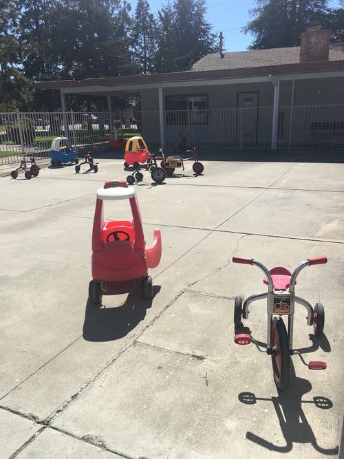 Children's ride-on toys and tricycles on a paved area