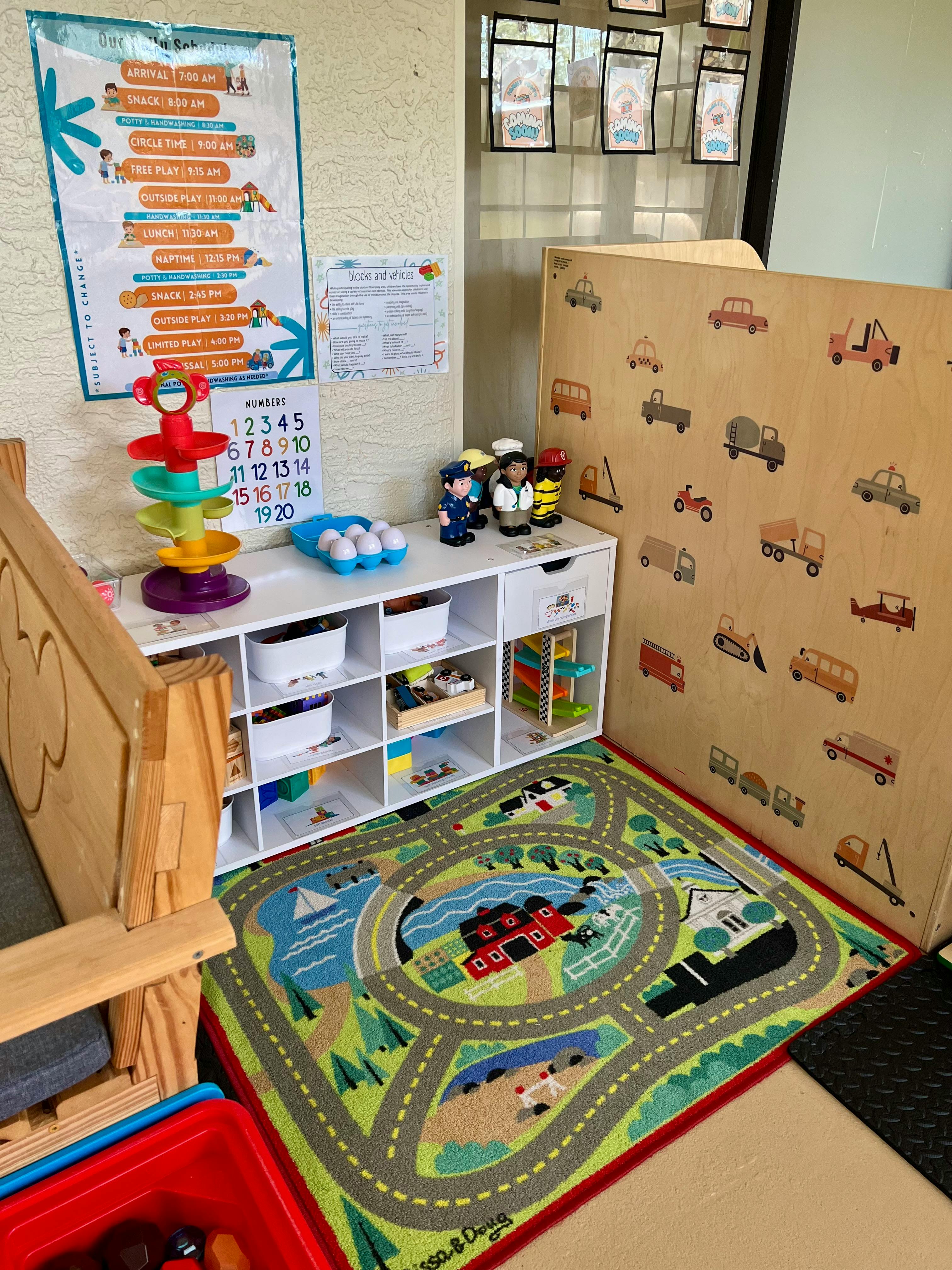 Playroom with a road map rug, toy shelf, and wall decorations