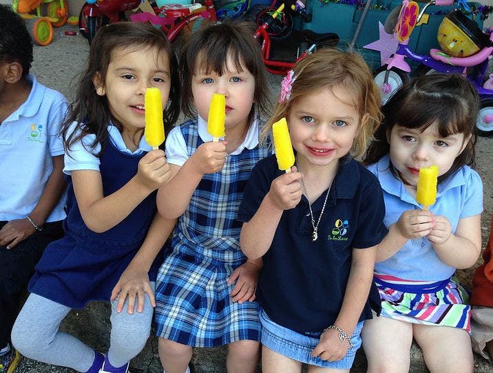 Four children holding yellow popsicles