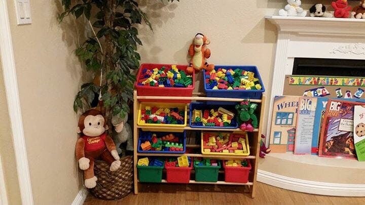 Toy organizer with colorful bins filled with building blocks and stuffed animals