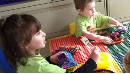 Two children playing with toys at a table